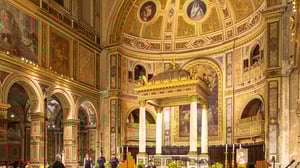Veduta dell’interno di una chiesa rinascimentale-barocca con decorazioni elaborate: affreschi parietali e cupola dorata con medaglioni raffiguranti santi, archi a tutto sesto decorati e un altare centrale sormontato da un baldacchino dorato sostenuto da colonne in marmo